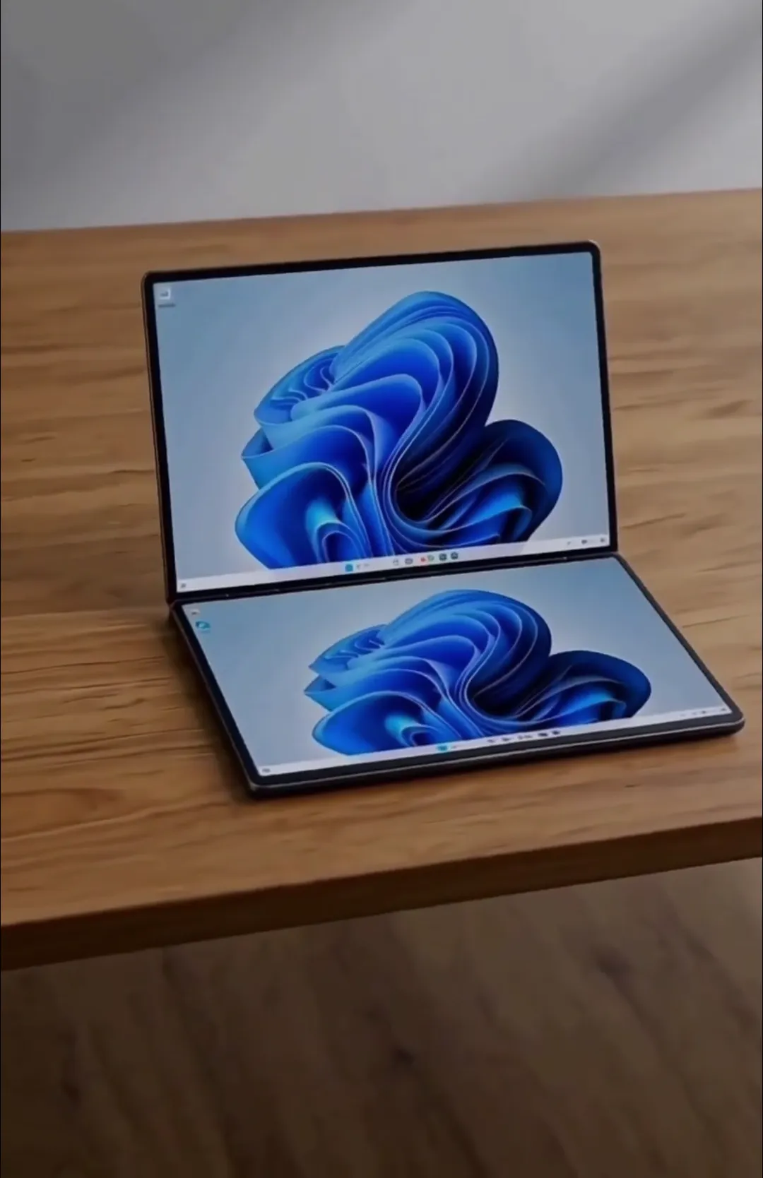 DanoSwift abierto del todo sobre una mesa de madera, con Windows 11 en las dos pantallas